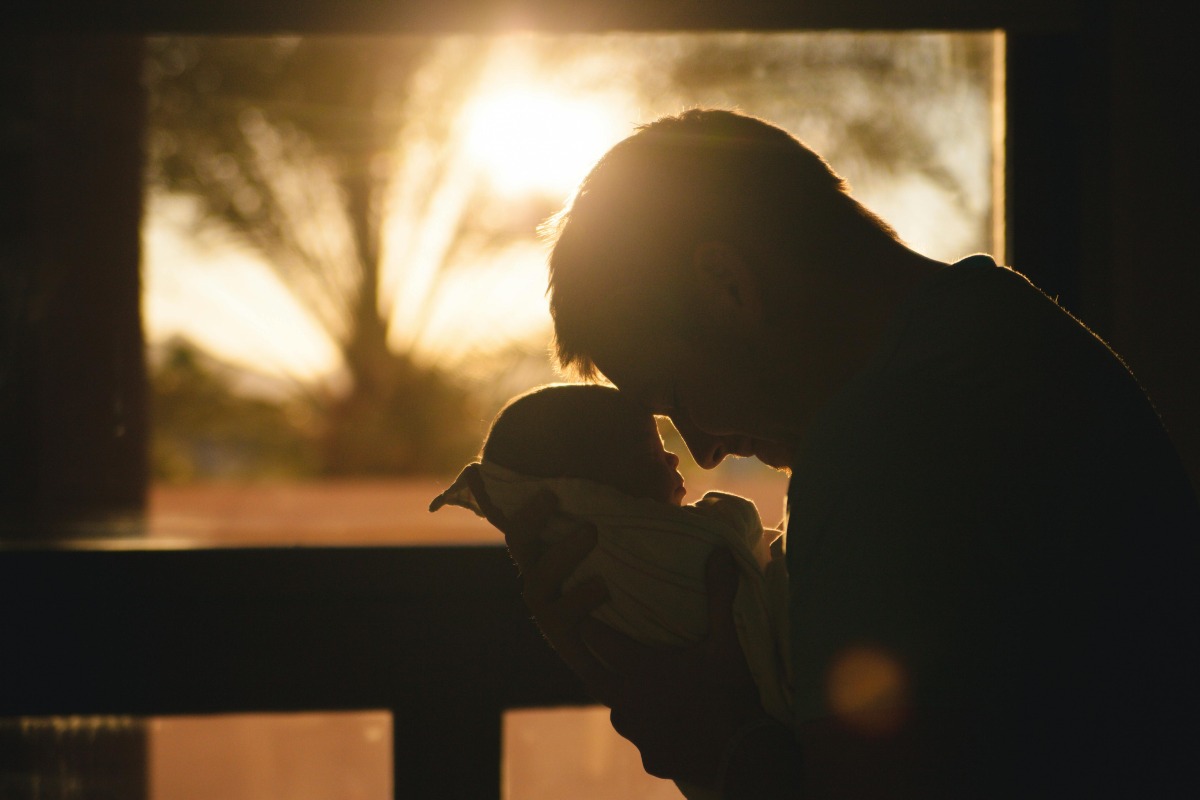 A father holds his newborn baby, a powerful motivation for seeking mental health and addiction recovery.