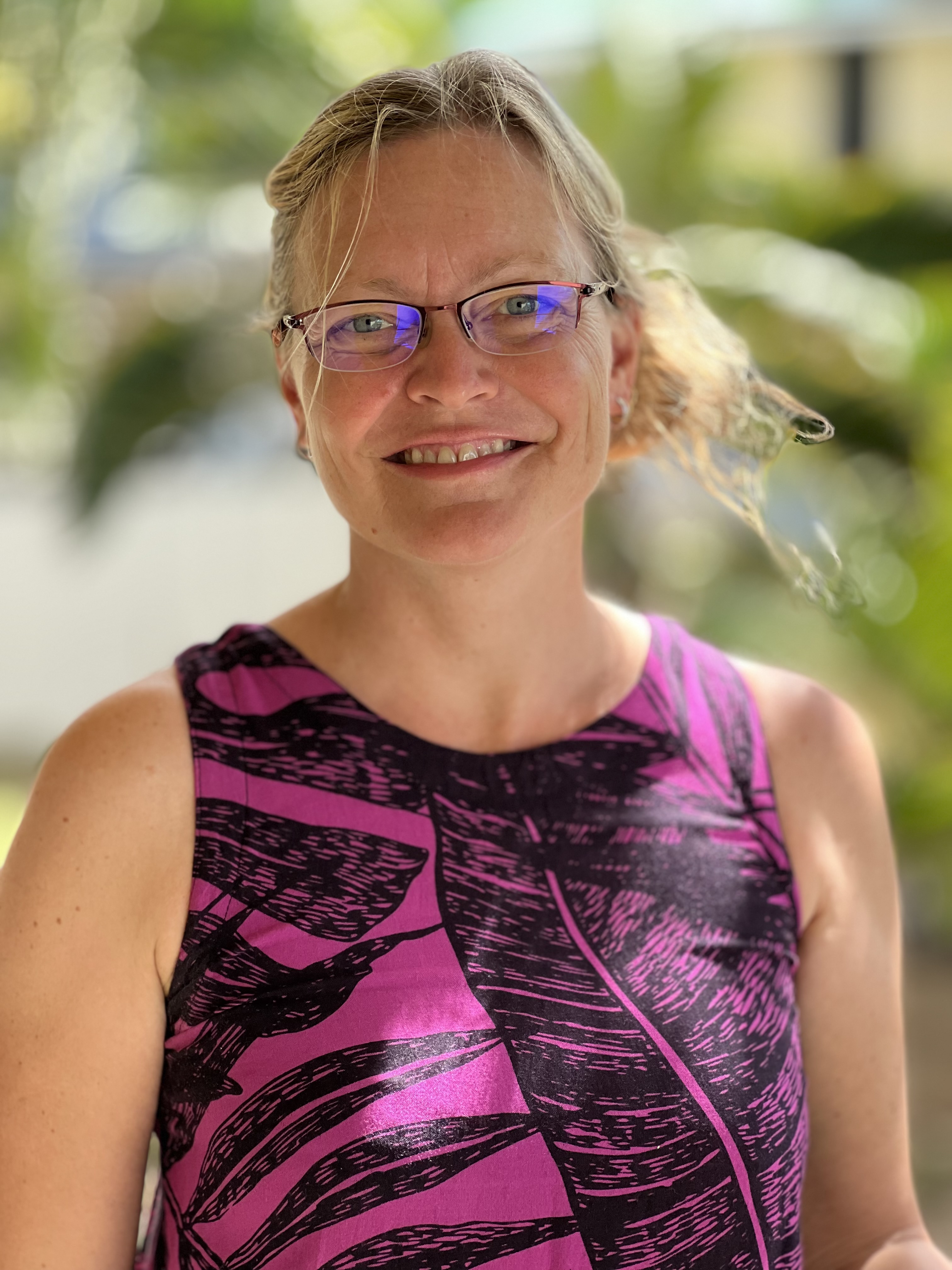 Sophie, an experienced and friendly therapist on our clinical team, smiles in a tropical setting.